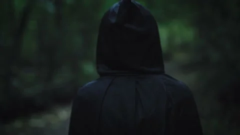 A dark figure in a black cloak with a ho... | Stock Video | Pond5