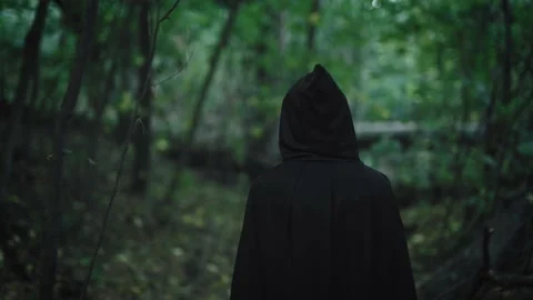 Premium Photo  A woman in a black robe stands in a dark forest.