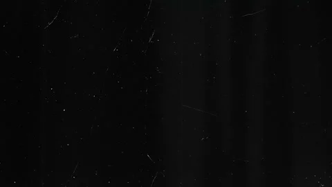 Dark film grain texture with subtle scratches and floating dust particles Stock Footage 333414380