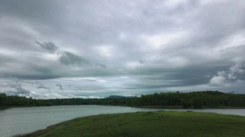 Dark fluffy blue rain clouds forming over floating lakeside during rain seaso Stock Footage 97811539