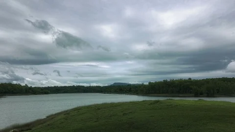 Dark fluffy blue rain clouds forming over floating lakeside during rain seaso Stock Footage 97811540