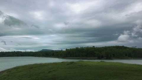Dark fluffy blue rain clouds forming over floating lakeside during rain seaso Stock Footage 97811608