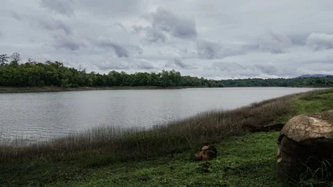Dark fluffy blue rain clouds forming over floating lakeside during rain seaso Stock Footage 97978478