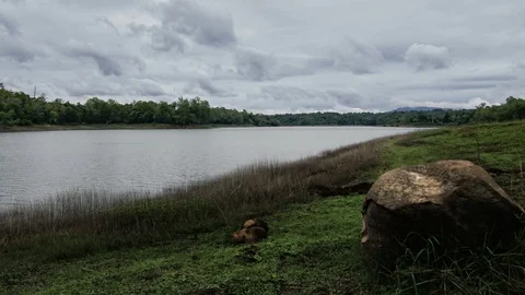 Dark fluffy blue rain clouds forming over floating lakeside during rain seaso Stock Footage 97978708