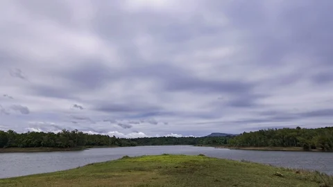 Dark fluffy blue rain clouds forming over floating lakeside during rain seaso Stock Footage 97987875