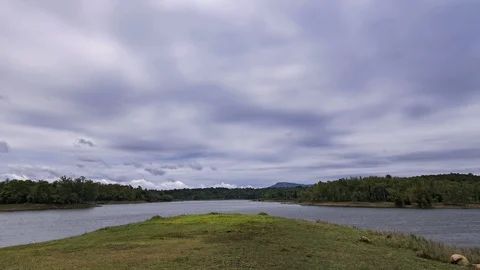 Dark fluffy blue rain clouds forming over floating lakeside during rain seaso Stock Footage 97987976