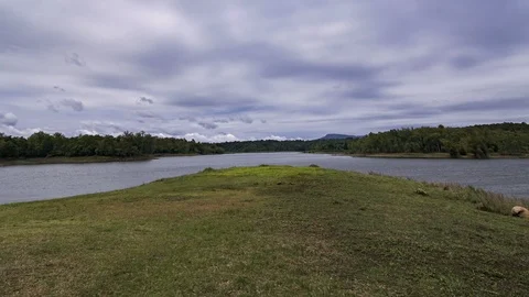 Dark fluffy blue rain clouds forming over floating lakeside during rain seaso Stock Footage 97988063