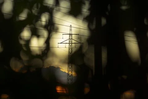 Dark foliage frames glowing tower revealing secrets of energy network Stock Photos