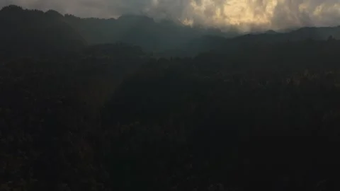 Dark forested mountains transition to bright sky with sun rays and clouds Vídeo Stock 334157306