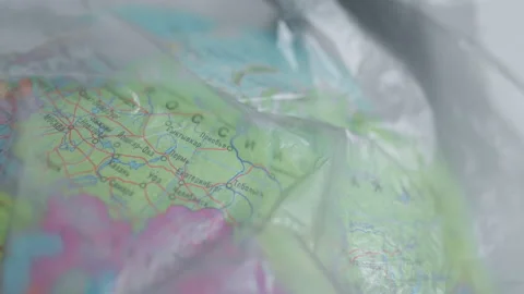 A dark garbage bag or polyethylene covers Russia on a globe Stock Footage 170156429