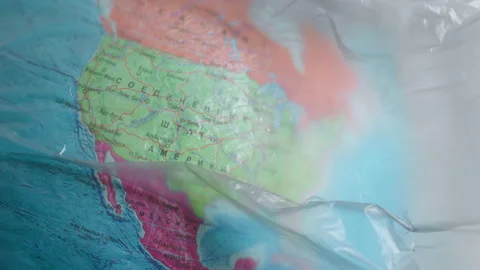 A dark garbage bag or polyethylene covers countries on a globe, USA, Mexico Stock Footage 170159463