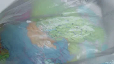 A dark garbage bag or polyethylene covers countries on a globe, Mongolia Stock Footage 170159479