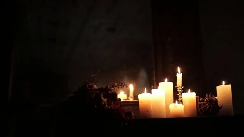 In a dark gothic room with tall windows on the piano lit candles Video stock 69169772