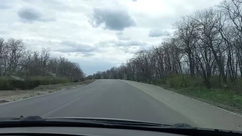 A dark gray car drives down a road in Ukraine during martial law. The side Video stock 200856582