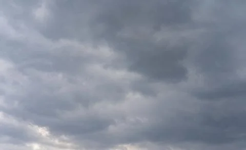 Dark gray clouds gather in the sky, signaling an approaching storm during l.. Stock Photos