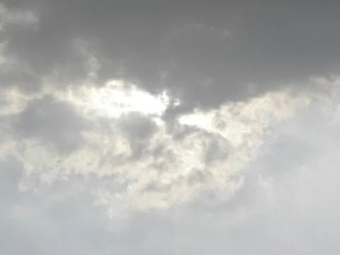 Dark gray clouds with sun rays coming out from behind the clouds Foto stock