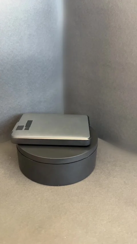 Dark gray external hard drive rotating on black base Stock Footage 330894323