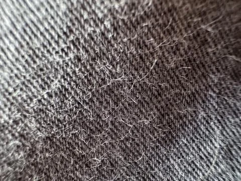 Dark gray fabric texture close-up with visible lint and pilling, worn texti.. Stock Photos