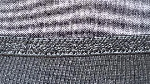 Dark gray fabric texture featuring detailed zigzag stitch pattern surface macro Stock Photos