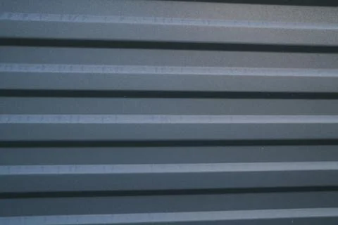 Dark gray metal siding surface with parallel horizontal pattern lines Stock Photos