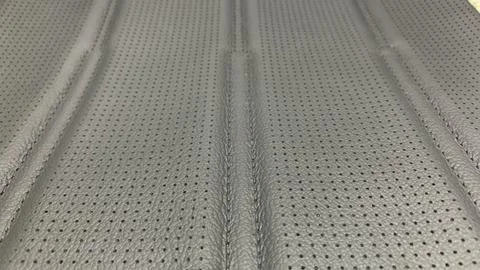 Dark gray perforated artificial leather background Stock Photos