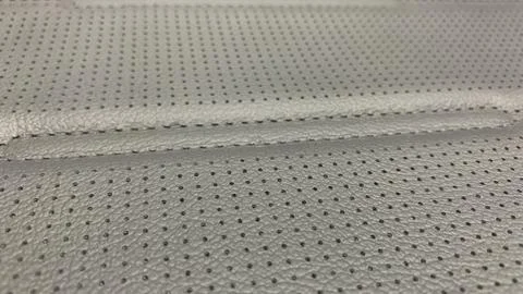 Dark gray perforated artificial leather background texture Stock Photos