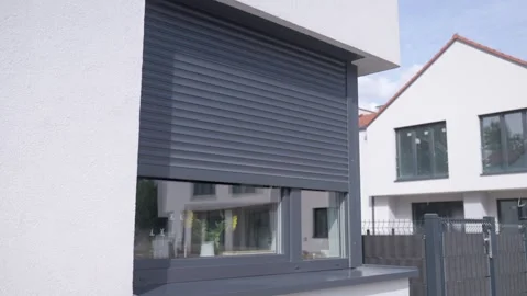 Dark gray roller shutter descends across modern residential window Stock Footage 340481847