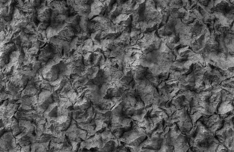Dark gray rough volcanic rock surface texture with deep crevices and shadows. Stock Illustration