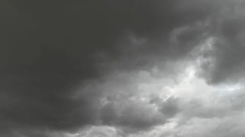 Dark gray storm clouds move across the sky with a small patch of blue sky.  Stock Footage 141618688
