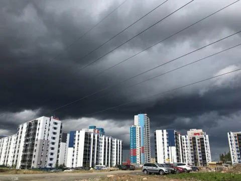 Dark gray Storm clouds under multi-storey building before the heavy rain Stock Photos