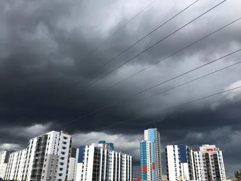 Dark gray Storm clouds under multi-storey building before the heavy rain Stock Photos
