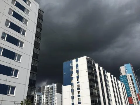 Dark gray Storm clouds under multi-storey building before the heavy rain Stock Photos
