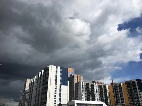 Dark gray Storm clouds under multi-storey building before the heavy rain Stock Photos