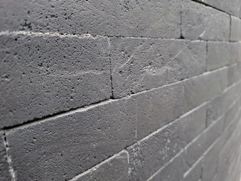 Dark gray volcanic stone wall with rough texture provides a natural and rus.. Stock Photos
