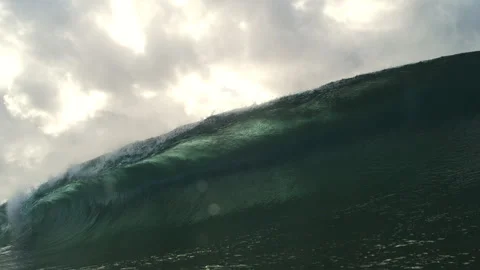 Dark Green Ocean Wave Rising Below Luminous Clouds Near Water Level Stock Footage 344388353