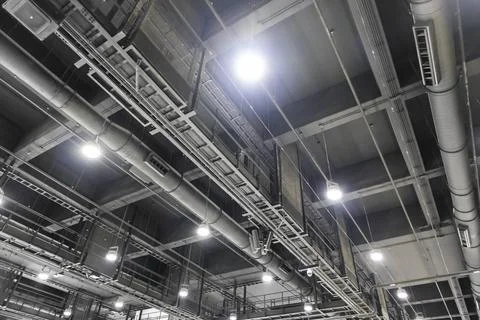 Dark grey air conditioning system and lighting system in large interior spa.. Stock Photos