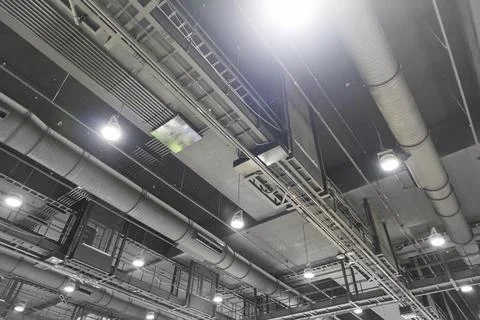 Dark grey air conditioning system and lighting system in large interior spa.. Stock Photos
