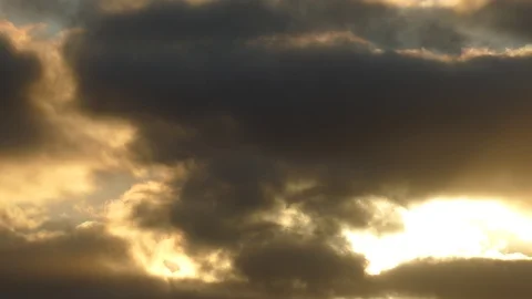 Dark grey and golden clouds with morning sun at sunrise - 4k Real Time Video Stock Footage 107944010