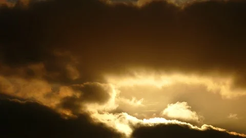 Dark grey and golden clouds with morning sun at sunrise - 4k Real Time Video Stock Footage 107948870