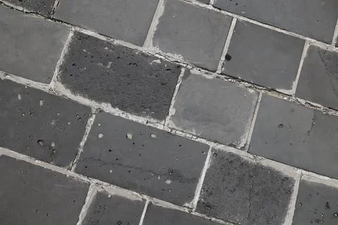 Dark grey basalt stone pavement texture from top view Stock Photos
