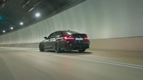 Dark grey bmw m3 driving rapidly through an illuminated underground tunnel Stock-Footage 341956121