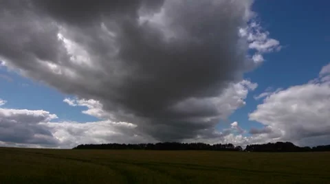 Dark grey clouds clearing to sunshine - time lapse Stock Footage 7742027