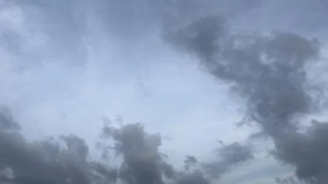 Dark grey clouds gather in an expansive sky above Stock Photos