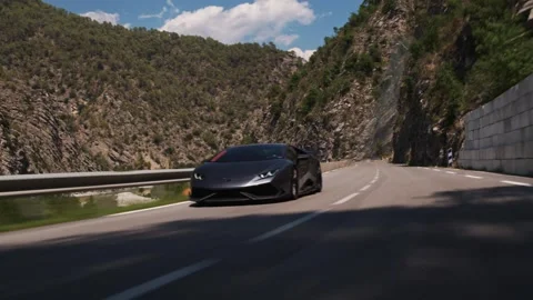 Dark grey lamborghini huracan speeding along a winding mountain road Stockbeeldmateriaal 341958282