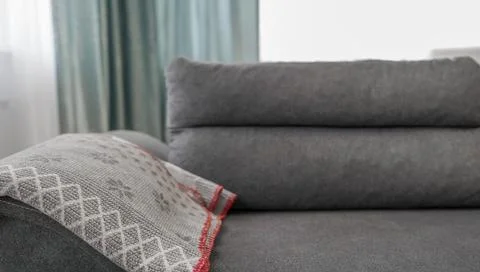 Dark grey modern sofa with a grey patterned throw blanket Stock Photos