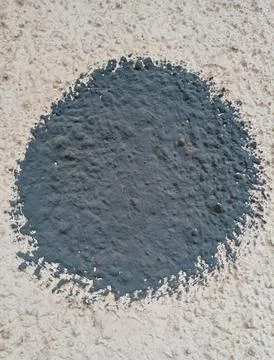 Dark grey painted circle on rough plaster wall Stock Photos