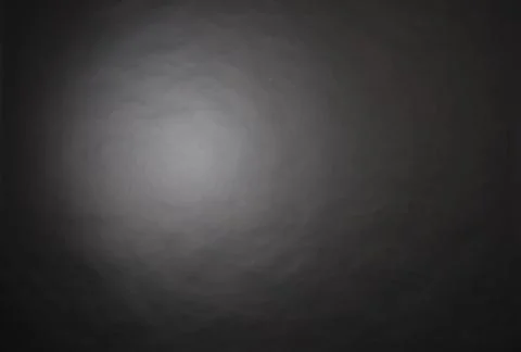 Dark grey studio backdrop lit up by a single light creating a drop off in lig Stock Photos