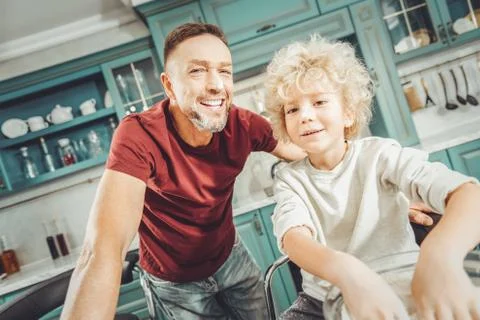 Dark-haired bearded father spending leisure time with his son Stock Photos