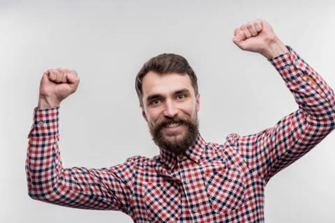 Dark-haired bearded office worker feeling happy after finishing project Stock Photos