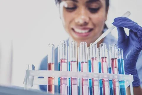 Dark-haired biologist looking at test tubes 스톡 사진